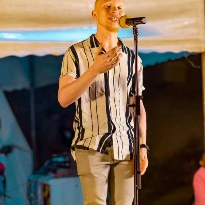 A poet with albinism performing.